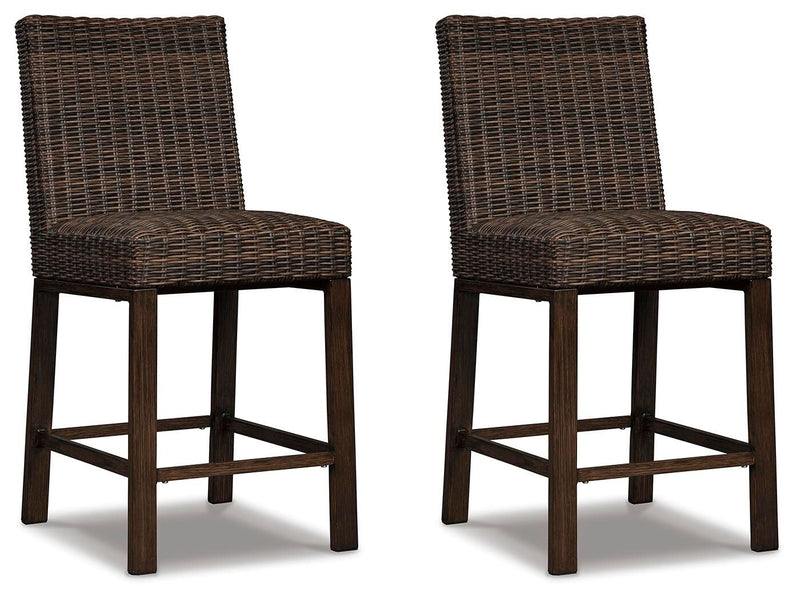 Set of two Signature Design by Ashley Paradise Trail barstools in medium brown wood with cushioned seats, modern and stylish for dining.