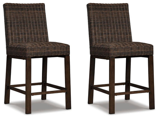 Set of two Signature Design by Ashley Paradise Trail barstools in medium brown wood with cushioned seats, modern and stylish for dining.