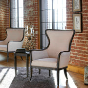 Uttermost Sandy wing back armchair in beige and dark brown fabric with wooden legs, showcasing its elegant design and plush cushioning.