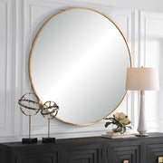 Uttermost Junius round wall mirror with a sleek, modern frame hanging on a wall, reflecting a stylish interior.