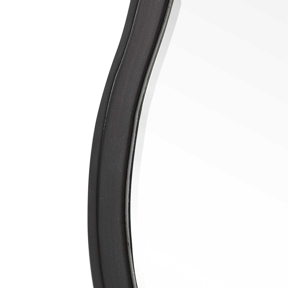 Uttermost Aneta round wall mirror with a sleek modern frame, hanging on a wall, showcasing its reflective glass surface.
