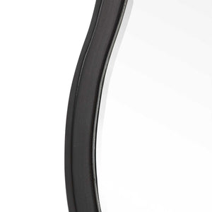 Uttermost Aneta round wall mirror with a sleek modern frame, hanging on a wall, showcasing its reflective glass surface.