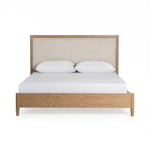 Upholstered bed in neutral fabric with a padded headboard by Classic Home, styled in a modern bedroom setting.