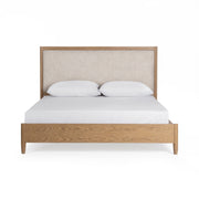 Upholstered bed in neutral fabric with a padded headboard by Classic Home, styled in a modern bedroom setting.