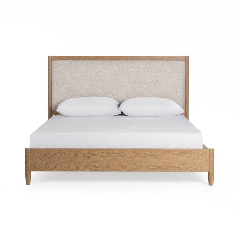 Upholstered bed in neutral fabric with a padded headboard by Classic Home, styled in a modern bedroom setting.