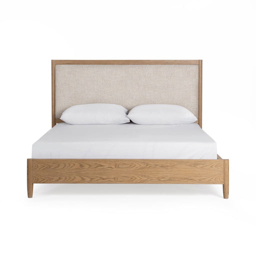 Upholstered bed in neutral fabric with a padded headboard by Classic Home, styled in a modern bedroom setting.