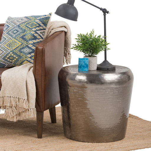 Antique silver metal accent table by Simpli-Home featuring a round top and sleek, modern design.