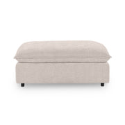 Classic Home Caplan upholstered ottoman with a plush fabric cover and sturdy wooden legs, perfect as a versatile footrest or accent piece.