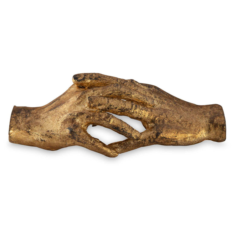 Gold "Hold My Hand" sculpture by Uttermost, depicting a detailed figurine of a person holding another's hand, in a sleek artistic style.