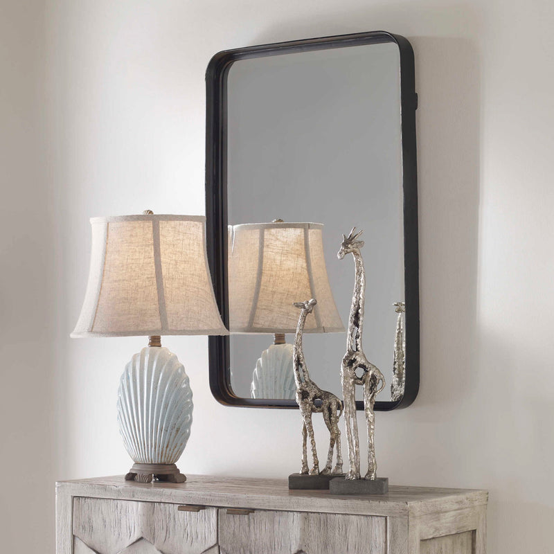 Black Croften vanity mirror by Uttermost with a sleek, modern design and a round reflective surface.