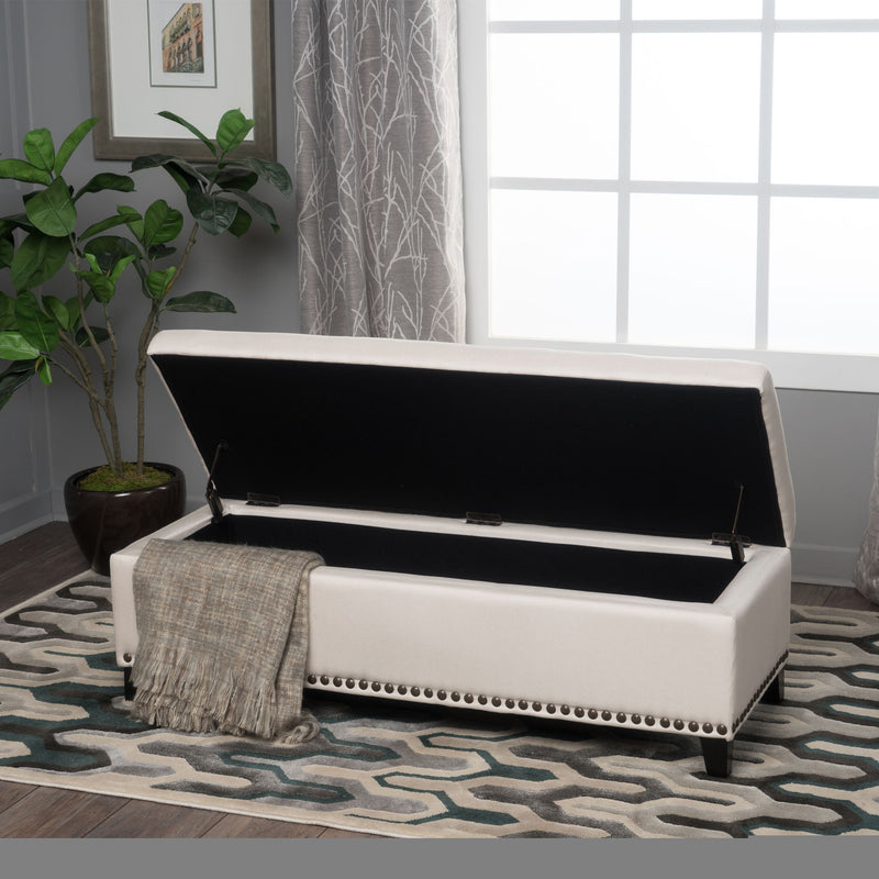 Beige upholstered storage ottoman with nailhead trim by Noble House, featuring a soft cushioned top and functional interior storage.