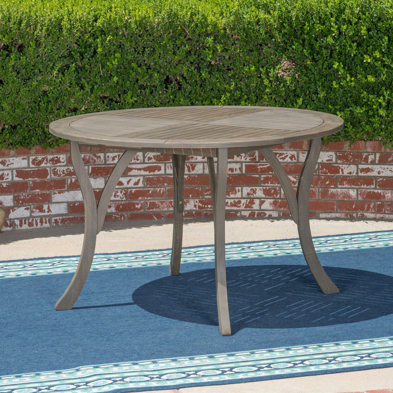 Hermosa outdoor acacia wood dining table with a circular design by Noble House, perfect for outdoor gatherings.