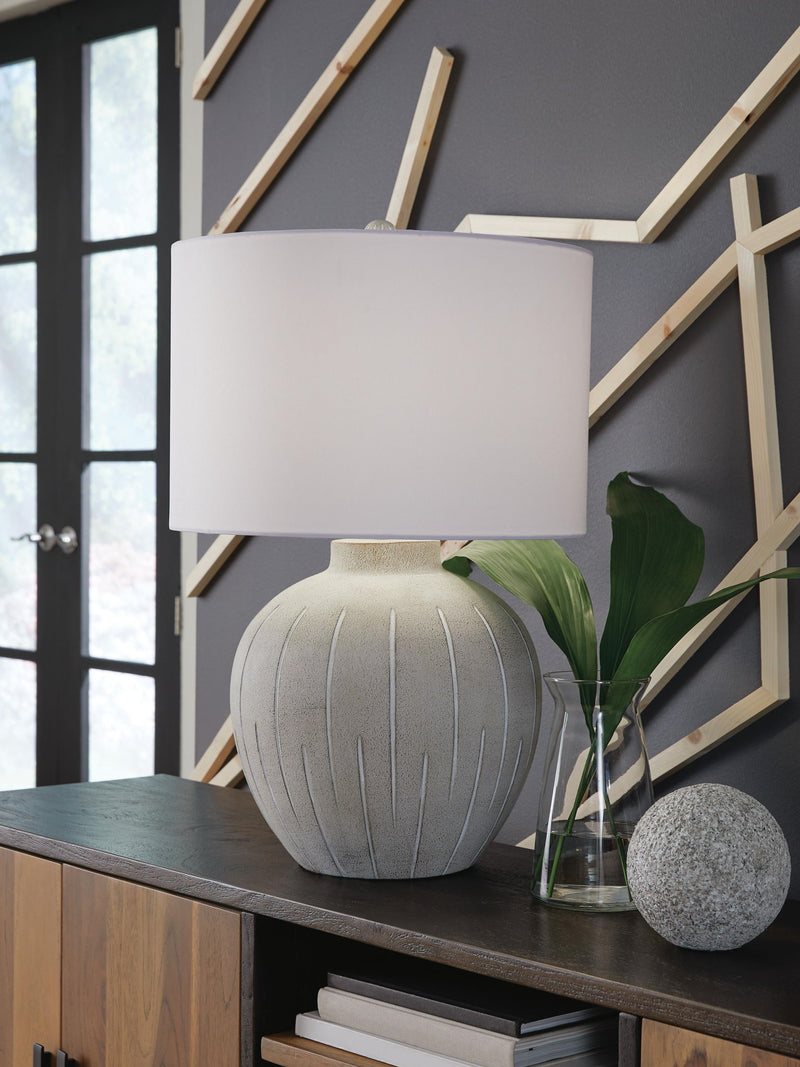 Calbert poly table lamp by Signature Design Ashley in warm gray with a modern, sleek design and soft illumination.