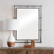 Uttermost Ironworks industrial black wall mirror with metal frame, modern design, reflecting a stylish interior space.
