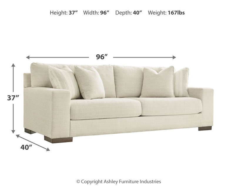 Signature Design by Ashley Maggie stationary sofa with plush cushions and neutral fabric upholstery in a modern living room setting.