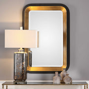 Uttermost Niva metallic wall mirror with a gold finish, round shape, and modern design on a plain background.