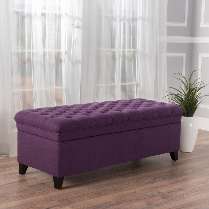 Noble House Juliana storage ottoman with birch wood legs, cushioned top, and spacious interior for extra storage.