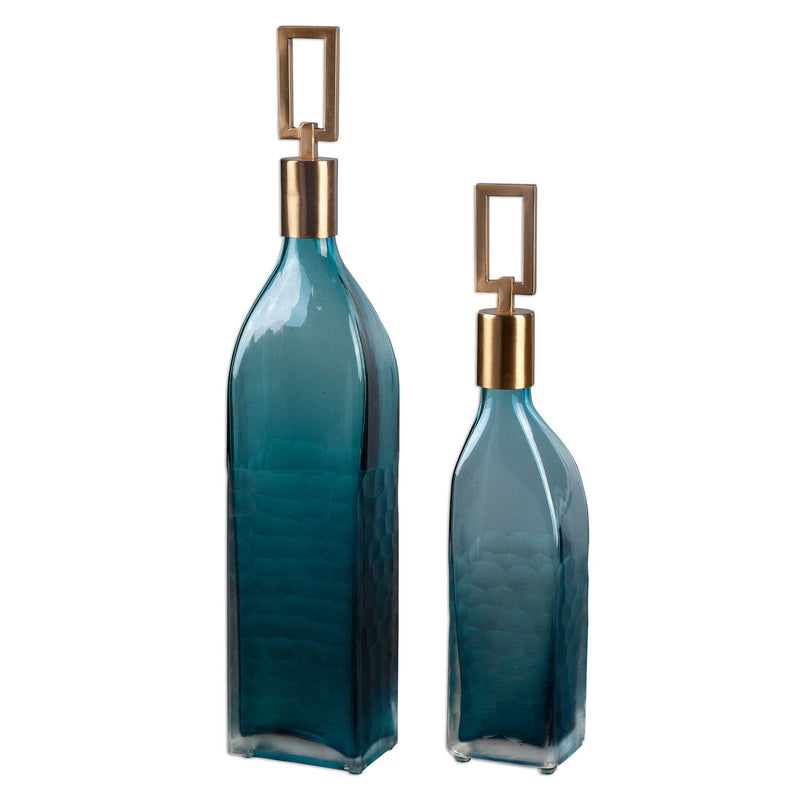 Set of two teal glass bottles by Uttermost, decorative vases with smooth curves and transparent teal color for stylish home decor.