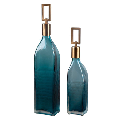 Set of two teal glass bottles by Uttermost, decorative vases with smooth curves and transparent teal color for stylish home decor.