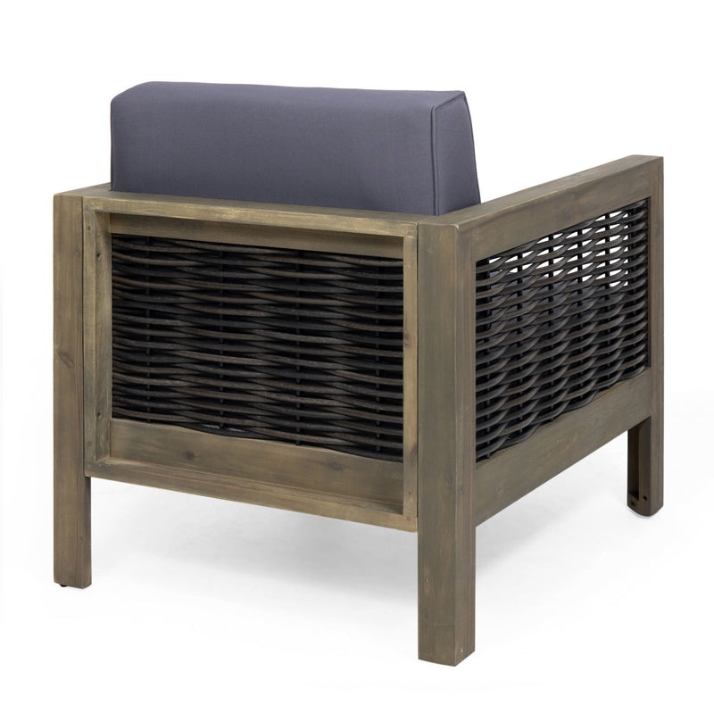 Outdoor acacia wood club arm chair with wicker accents, rustic design, and cushioned seat for comfortable outdoor seating.