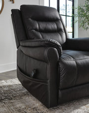 Signature Design by Ashley Oatman power lift recliner in neutral fabric, showing its plush cushioned back and armrests.