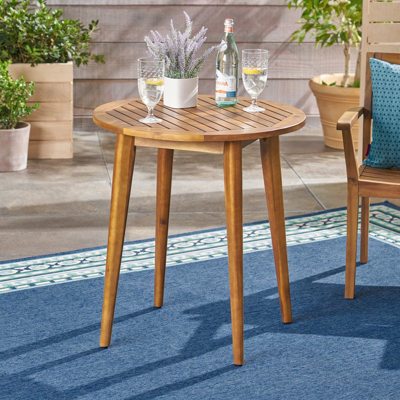 Noble House Stamford modern outdoor bistro table with water-resistant teak finish, ideal for patio or garden dining.