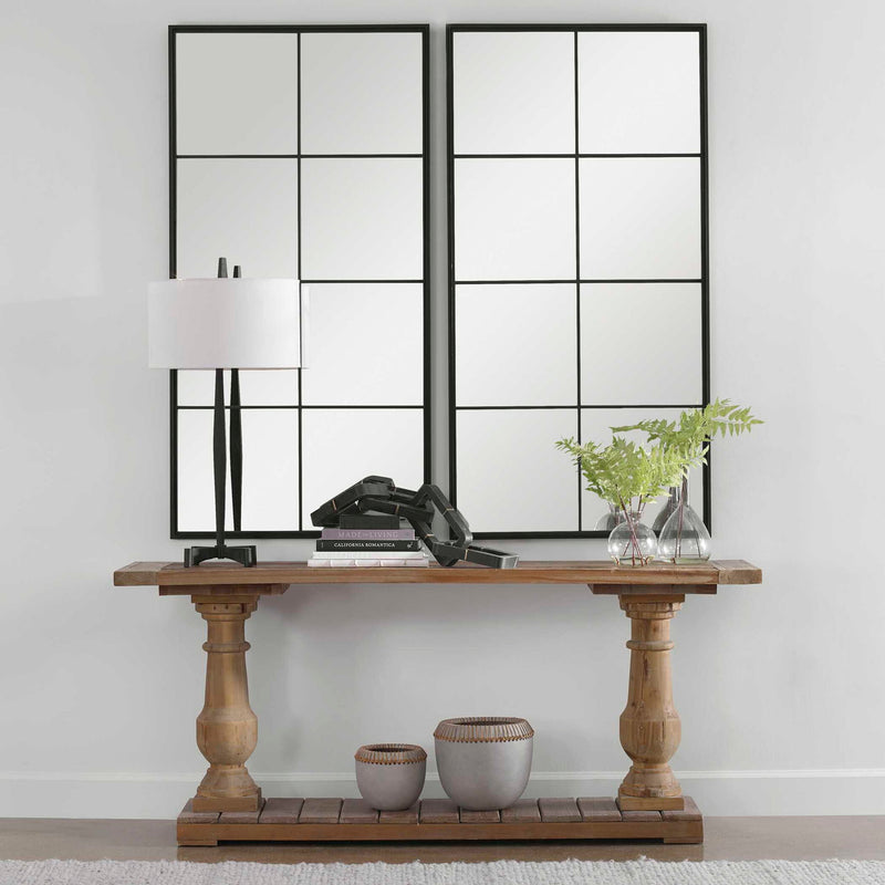 Black iron window mirror by Uttermost featuring a grid-style accent design, mounted on a wall showing reflections.