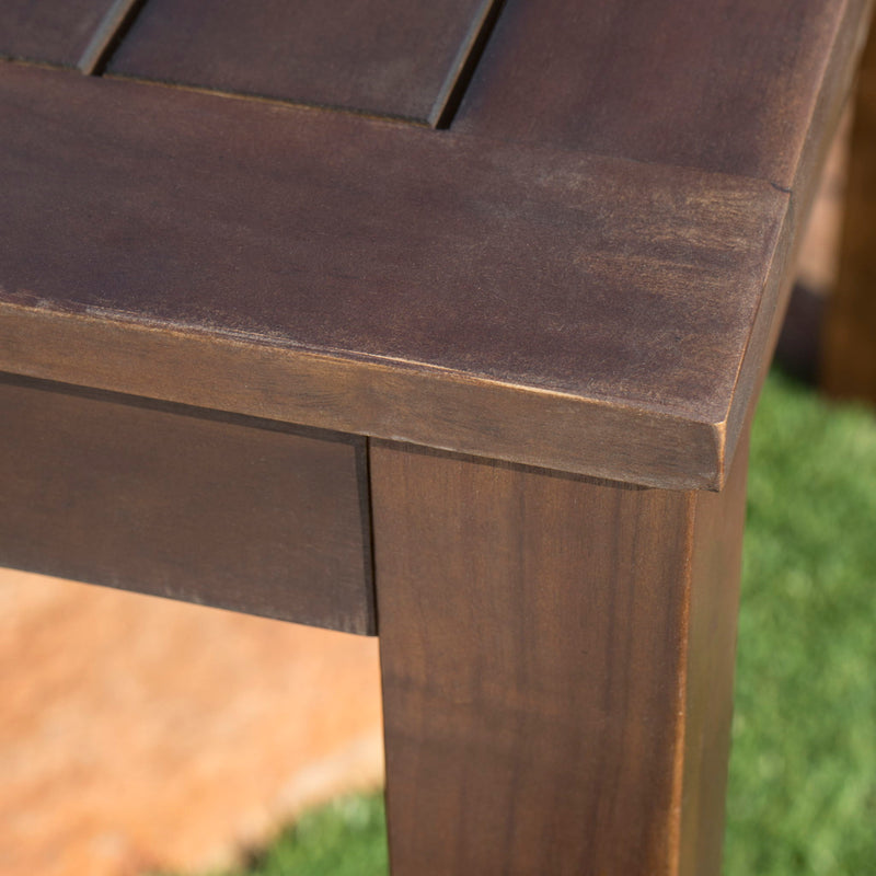 Dark brown acacia wood outdoor dining table with slatted top, perfect for patio or garden dining spaces.