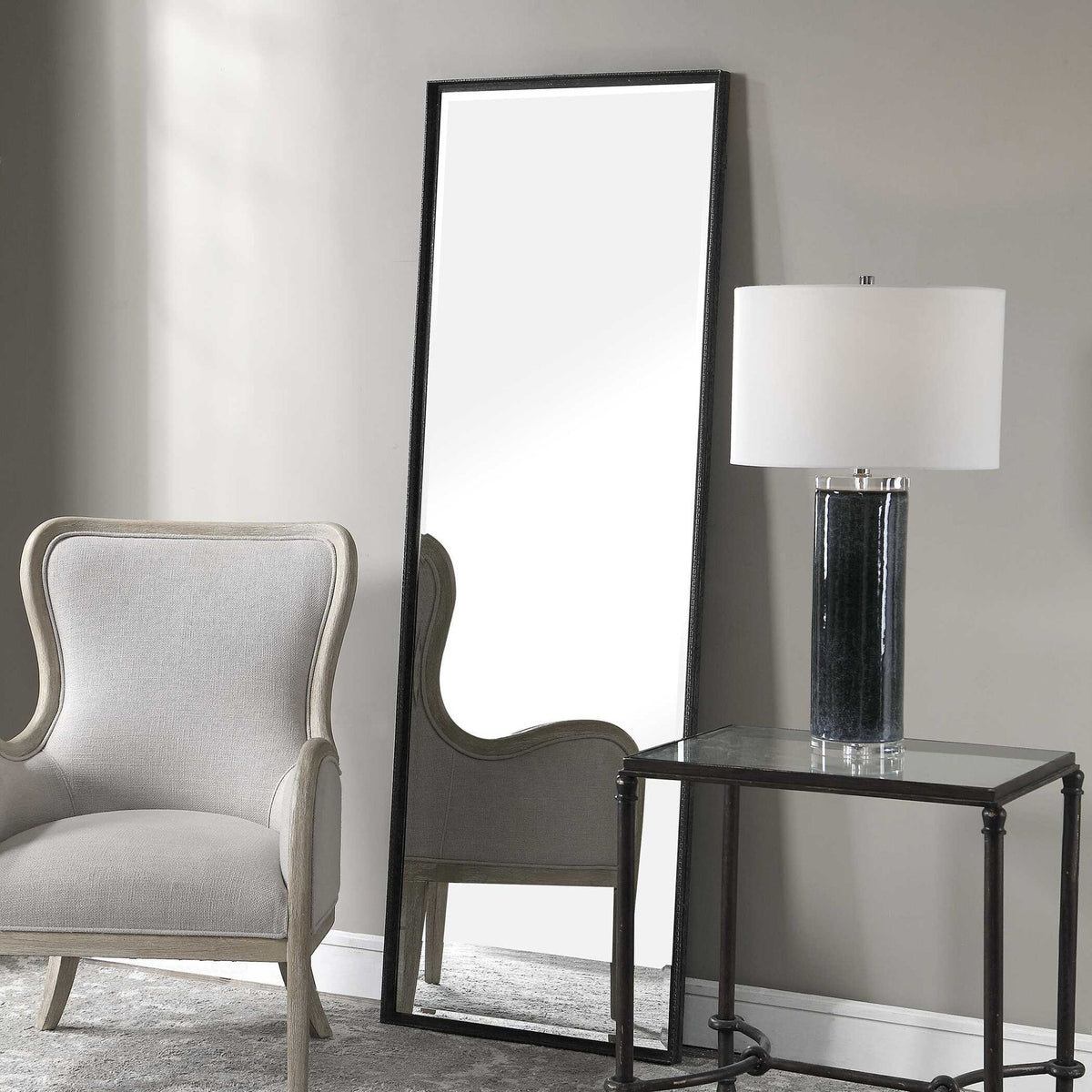 Uttermost Callan Leaner Mirror in black with a sleek, modern frame, standing tall against a neutral background.