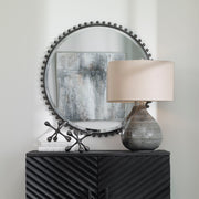 Round iron wall mirror by Uttermost with a sleek, minimalist design suitable for modern interior decor.