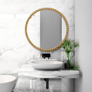 Round gold Byzantine wall mirror by Uttermost with ornate, detailed frame suitable for elegant home decor.