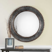 Uttermost Tanaina round wall mirror with silver frame, reflecting light and adding modern elegance to a living space.