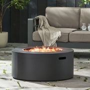Round Noble House iron fire pit with 40,000 Btu, featuring a sturdy design and open top for outdoor warmth and ambiance.