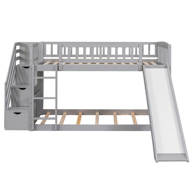 Gray DreamHaus twin over twin bunk bed with stairway, two drawers, and slide, featuring a sturdy frame and safety railings.