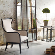 Uttermost Sandy wing back armchair in beige and dark brown fabric, showcasing plush upholstery and classic design details.