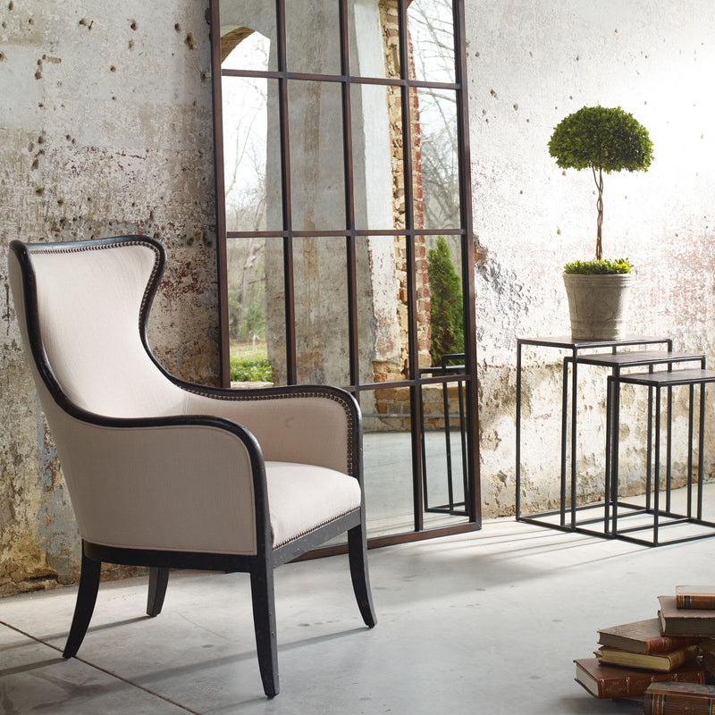 Uttermost Sandy wing back armchair in beige and dark brown fabric, showcasing plush upholstery and classic design details.
