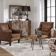 Dark brown leather armchair from Uttermost featuring a classic design, plush cushioning, and sturdy wooden legs.