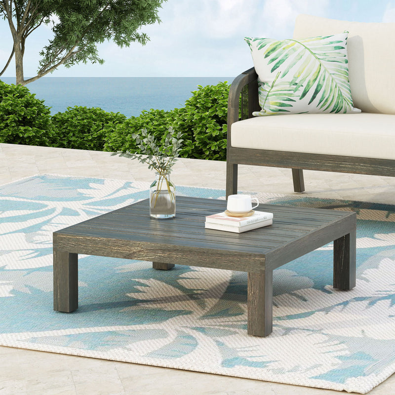 Rustic gray Noble House Oana Brava coffee table with slat panel design, showcasing a sturdy wooden surface and modern rustic style.