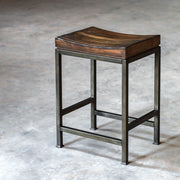 Industrial Beck counter height bar stool by Uttermost featuring metal frame and wooden seat, suitable for kitchen or bar area.