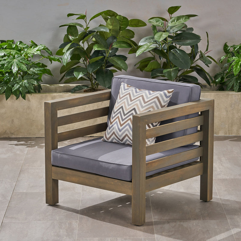 Outdoor Acacia wood patio arm chair with fabric cushion by Noble House, showcasing a stylish and comfortable outdoor seating option.