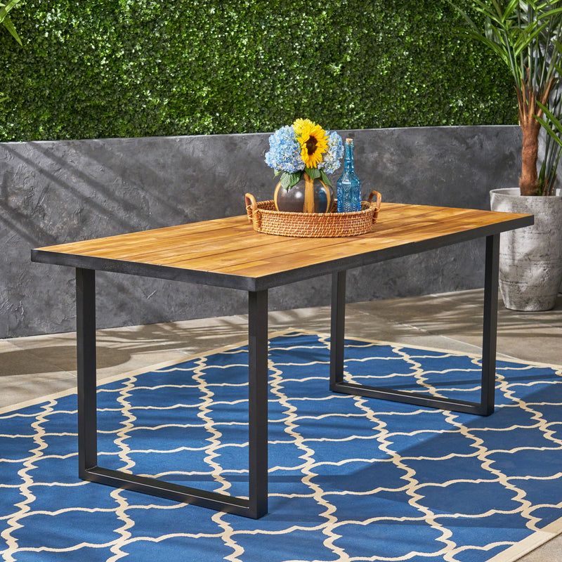 Outdoor teak dining table with U-shaped legs and slat top, designed for outdoor patio dining by Noble House.