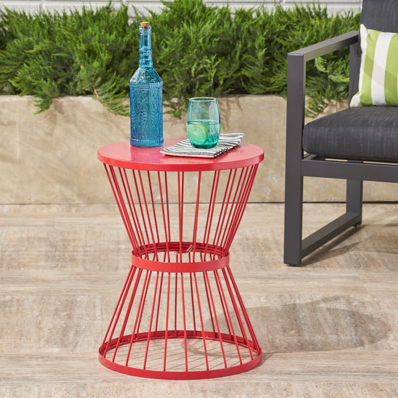 Noble House Lassen modern outdoor side table with hourglass design, featuring sleek black metal frame and round tabletop.
