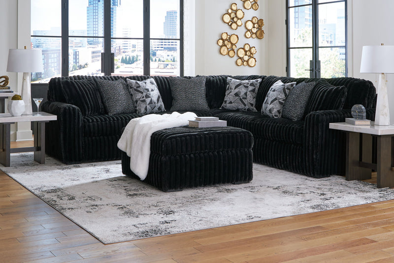 Signature Design by Ashley Midnight Madness 4-piece sectional set with plush cushions and modern upholstery for stylish living room decor.