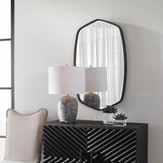 Uttermost Duronia iron wall mirror with a sleek, modern frame reflecting a stylish interior.