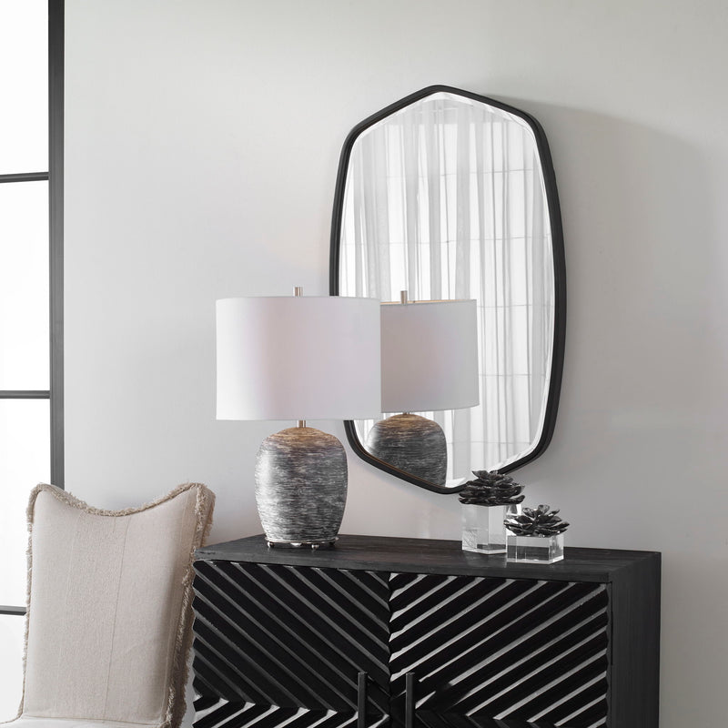 Uttermost Duronia iron wall mirror with a sleek, modern frame reflecting a stylish interior.