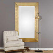 Gold wall mirror by Uttermost, Chaney style with a sleek round frame, hanging on a wall for stylish home decor.