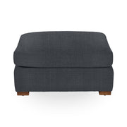Classic Home Audrey upholstered ottoman with fabric cushioning and wooden legs, ideal as a footrest or extra seating.