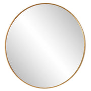 Uttermost Junius round wall mirror with a sleek frame, hanging on a wall, reflecting a modern interior.