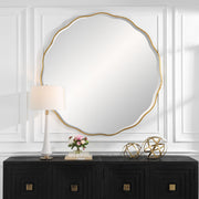 Uttermost Aneta round wall mirror with a sleek metal frame hanging on a modern wall.