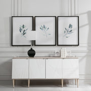 Set of three framed watercolor sage green prints by Uttermost, featuring simple botanical designs on white backgrounds.
